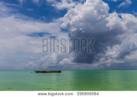 One Old, Homemade Wooden Boat In The Ocean Against The Horizon In The Sunny Day.