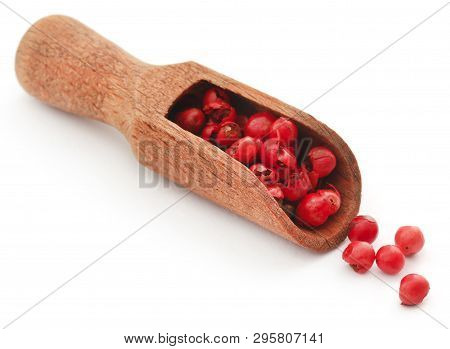 Pink Peppercorn In A Wooden Scoop Over Whtie Background