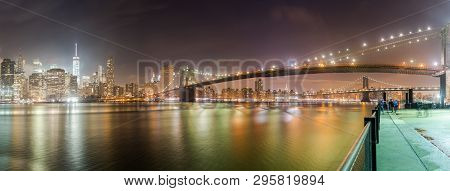 A Wider Panorama Of The Brooklyn Bridge At Night With The New York City Skyline In The Background. T