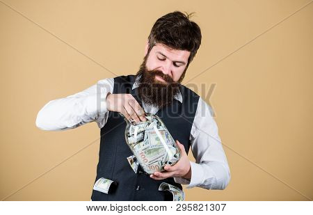 Hiding Money For Future Use. Bearded Man Investing Money From Glass Jar For Future Profits. Business