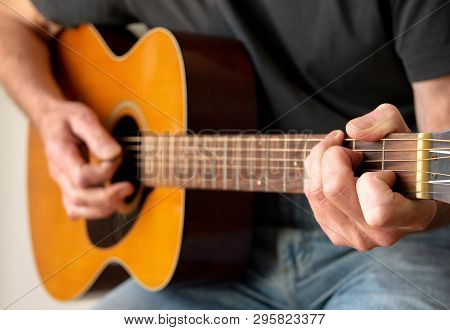 Man Strumming A C Chord Whilst Playing An Acoustic Guitar
