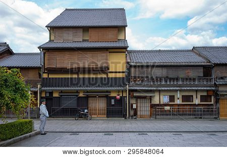 Kyoto, Japan - June 12, 2017: The Traditional Wooden Housse Of The Gion District With A Policeman In
