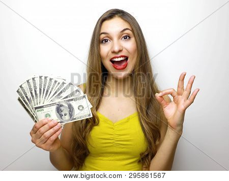 Woman Holding Cash Notes Isolated Over White Background. Young Woman In Big Winning Pose, Okay Sign.