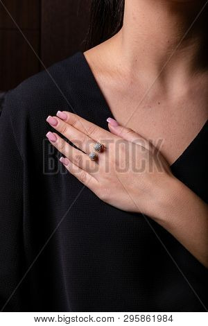 Womens Gold Diamond Ring In The Shape Of A Square With A Fringe On Finger, On A Black Background.