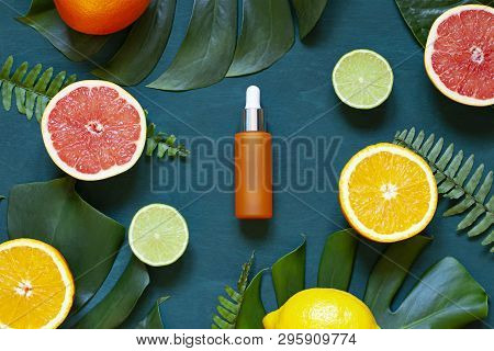 Cosmetic Flat Lay With Vitamin C Serum And Citrus On The Back Wooden Background. Top View