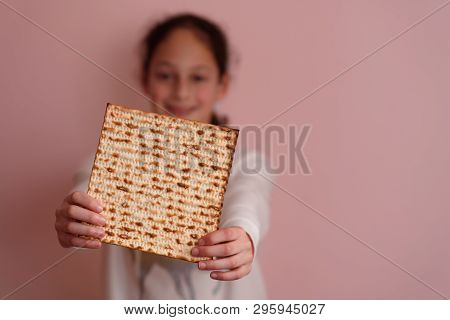 Portrait Of The Cute Teenager Girl Holding Matzah. Jewish Child Eating Matzo Unleavened Bread In Jew