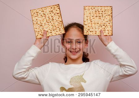 Portrait Of The Cute Teenager Girl Holding Matzah. Jewish Child Having Fun And Eating Matzo Unleaven