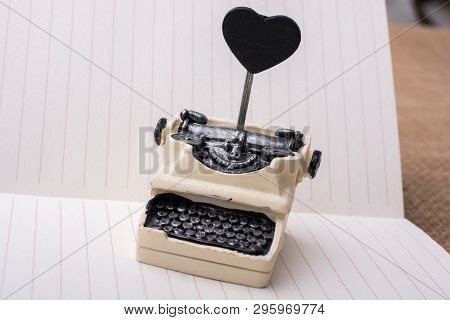 Retro Syled Tiny Typewriter Model On A Paper Background