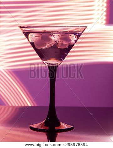 Glass With Cocktail And Ice On A Beautiful Background With Neon Stains