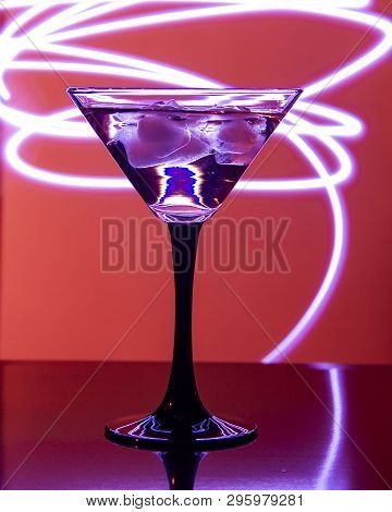Glass With Cocktail And Ice On A Beautiful Background With Neon Stains