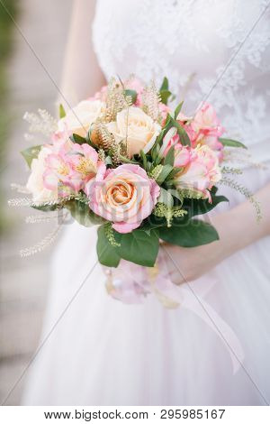 The Bride Holds A Delicate Wedding Bouquet Of Roses, Alstromeria, Talei And Salala