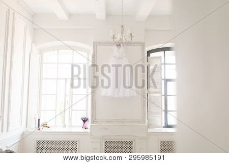 In A White Room On The Wall Between The Two Windows In The Frame Hangs A Magnificent Wedding Dress. 