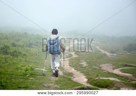 Hiker Walking In The Mountains On Foggy Summer Day. Hiking Trail In The Pyrenees. La Rhune Mountain,