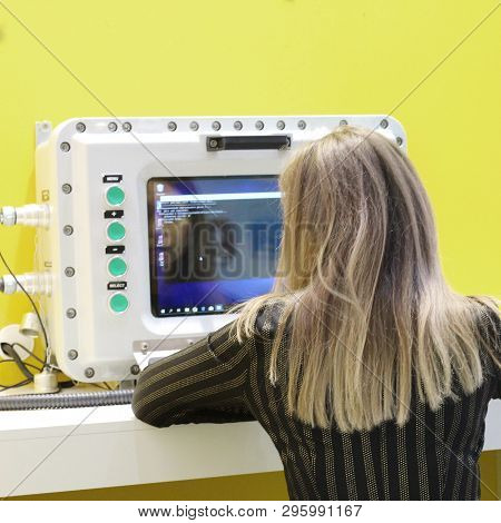 The Girl Operator Is Sitting Behind An Explosion-proof Monitor At A Refinery. Explosion-proof Comput