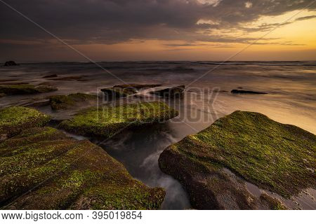 Calm Ocean Long Exposure. Stones Covered By Geen Moss In Mysterious Mist Of The Sea Waves. Concept O