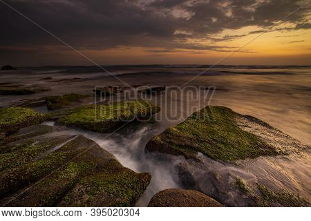Calm Ocean Long Exposure. Stones Covered By Geen Moss In Mysterious Mist Of The Sea Waves. Concept O