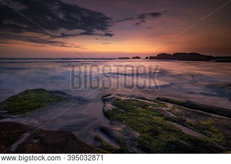 Calm Ocean Long Exposure. Stones Covered By Geen Moss In Mysterious Mist Of The Sea Waves. Concept O
