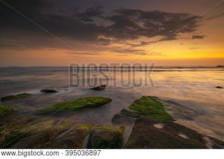 Calm Ocean Long Exposure. Stones Covered By Geen Moss In Mysterious Mist Of The Sea Waves. Concept O
