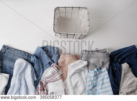 A Group Of Organic Cotton Clothing Set On A White Table Is Ready To Be Folded Into White Baskets.the