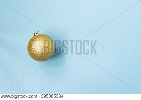 Golden Christmas Ball On A Blue Background. New Year Mood Mok Up. Copy Space