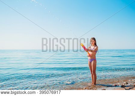 Adorable Active Little Girl At Beach During Summer Vacation
