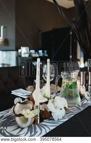 Served Tables For Wedding Banquet With Plates Restaurant. Decor From Fresh Flowers, Coconuts And Lea