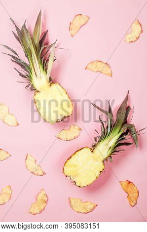 Ripe Juicy Pineapple On Pink Background And Dried Pineapple Wedges Around. Fruit Chips. Healthy Eati