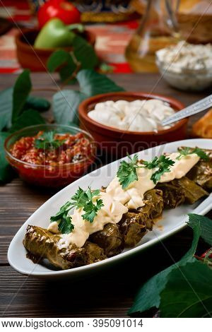Mediterranean Cuisine - Dolma In Plate With Fresh Cilantro And Sauce On Dark Wooden Table, Close-up 