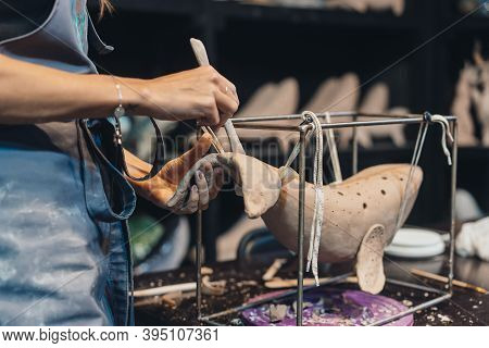 Close-up View Of Female Hands Gently Handling A Clay Whale In Workshop.