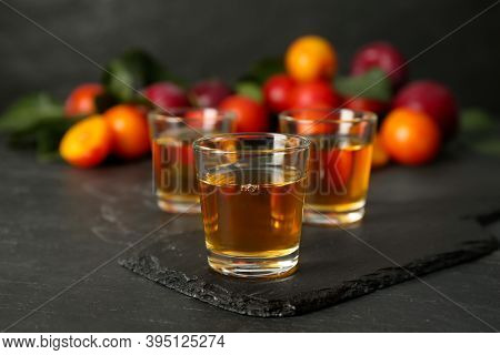 Delicious Plum Liquor On Black Table. Homemade Strong Alcoholic Beverage