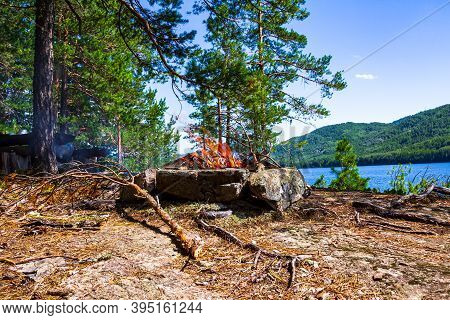 Fishermen's Bivouac On The Island. A Burning Bonfire. Lake Tagasuk. Krasnoyarsk Territory, Siberia, 