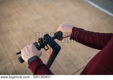 Electric Skate With Hands Touching The Buttons. Young Man With An Electric Skate To Move Around The 