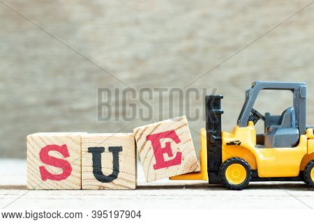 Toy Forklift Hold Letter Block E To Complete Word Sue On Wood Background
