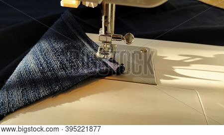 Sewing Process On A Modern Sewing Machine, Close-up. Sewing Machine Foot With A Needle. Dark Blue Fa