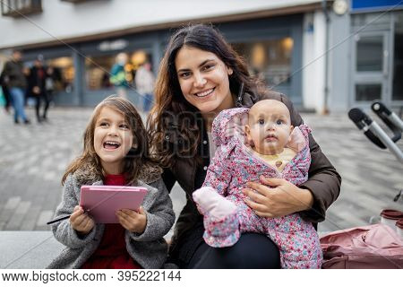 Happy Mother Smiling And Sitting Alongside Her Happy Daughters