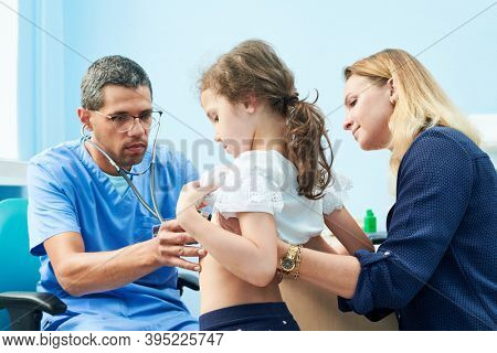 Pedeatrician african doctor examining little girl with stethoscope