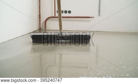 Leveling The Screed With A Roller. Interior Of Apartment Under Construction. Roller Application. Mir