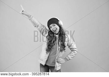 Small Kid Listen Music Headset. Child Long Curly Hair. Hair Care In Winter Season. Warm Clothes For 
