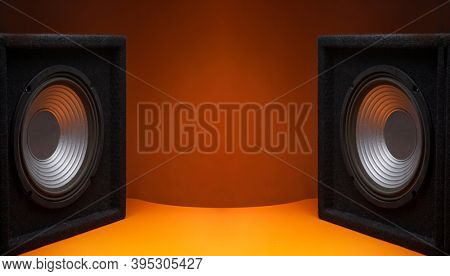 Black subwoofer speaker car audio music system on orange background