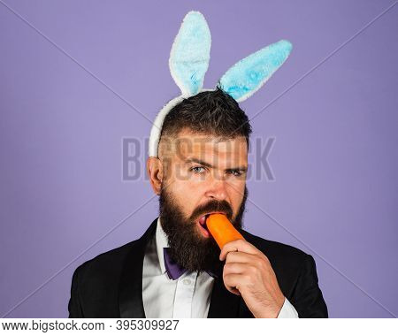 Easter Bunny Man Nibbles A Carrot Like A Hare. Healthy Man On Holiday. Easter Copy Space. Happy East