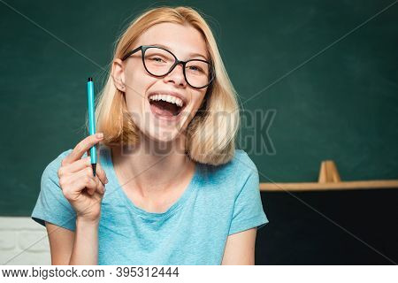 Young Woman Sitting At Table Doing Assignments Library. Young Happy Student. World Teachers Day. Hap