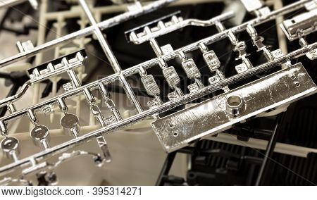 Plastic model making. Chrome plastic model parts still attached to runner or sprue.