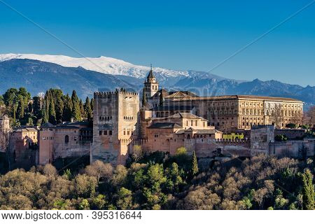 View Of Alhambra Palace In Granada, Spain With Sierra Nevada Mountains At The Background