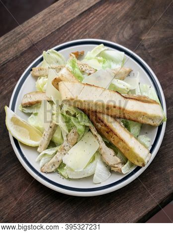 Simple Healthy Orgaanic Chicken Caesar Salad On Wood Table