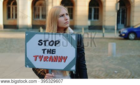 Young Woman Calling To Stop The Tyranny By Holding Steamer. Protest Walk In The City Center.