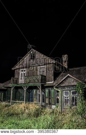 Old Spooky Abandoned Wooden House Illuminated On Black Night Background