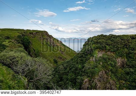 Scottish Landscape With Hills And Gorge Near Staffin At Isle Of Skye With Green Pastures Covered By 