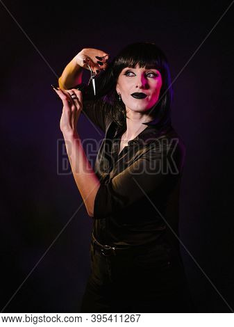 A Woman On A Black Background With A Black Haircut, Black Lips, A Black Silk Shirt Looks To The Side