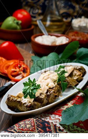 Mediterranean Cuisine - Dolma In Plate With Fresh Cilantro And Sauce On Dark Wooden Table, Close-up 