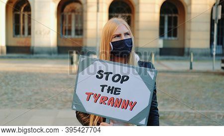 Young Woman In Protective Mask Calling To Stop The Tyranny By Holding Steamer. Protest Walk In The C